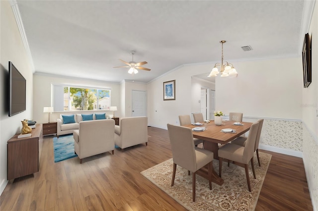 dining area with ornamental molding, vaulted ceiling, and wood-type flooring