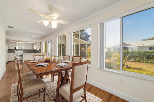 dining room featuring ornamental molding, hardwood / wood-style floors, and ceiling fan