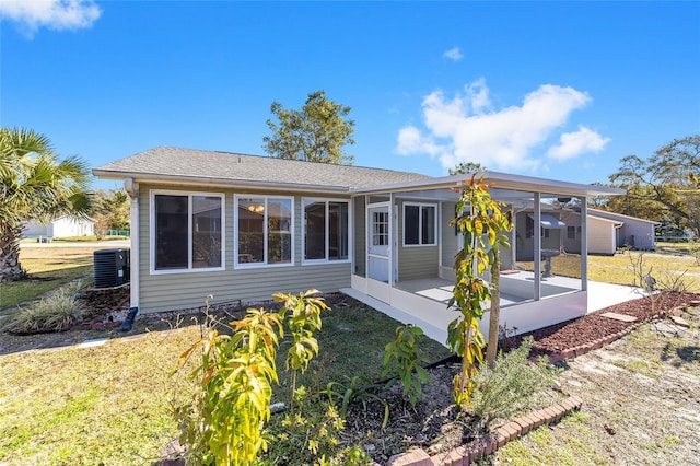 back of property with cooling unit, a patio, and a lawn