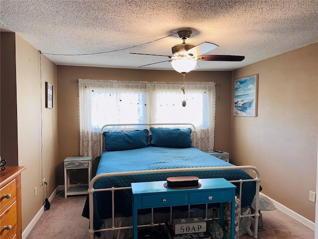 bedroom featuring multiple windows, a textured ceiling, ceiling fan, and carpet