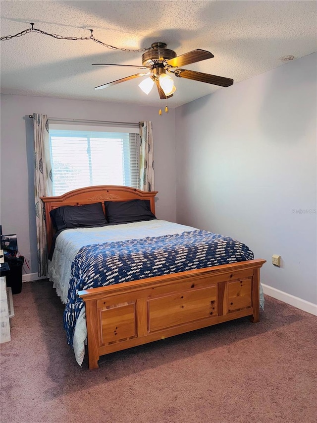 bedroom with ceiling fan, a textured ceiling, and dark carpet