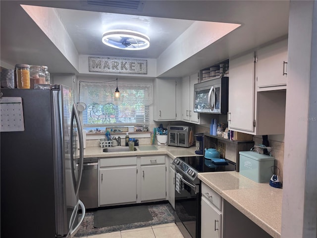 kitchen featuring light tile patterned floors, sink, hanging light fixtures, stainless steel appliances, and white cabinets