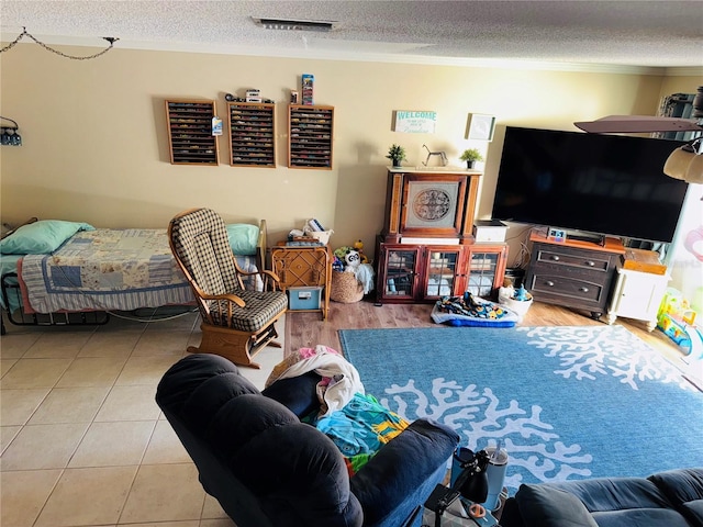 tiled living room featuring ornamental molding and a textured ceiling