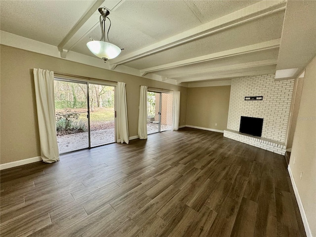 unfurnished living room with dark hardwood / wood-style floors, a textured ceiling, a fireplace, and beam ceiling