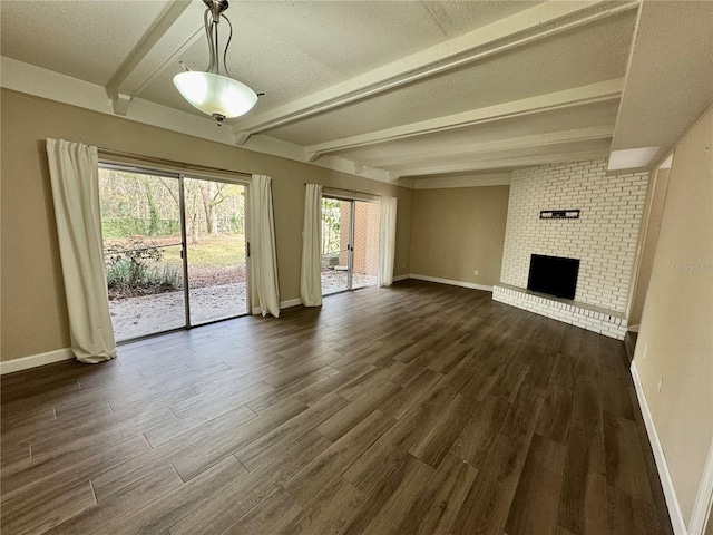 unfurnished living room featuring dark hardwood / wood-style flooring, a textured ceiling, a fireplace, and beamed ceiling