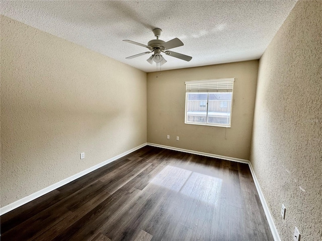 empty room featuring dark wood-type flooring, ceiling fan, and a textured ceiling