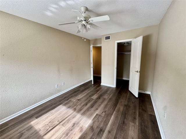 unfurnished bedroom with dark hardwood / wood-style flooring, a textured ceiling, a closet, and ceiling fan