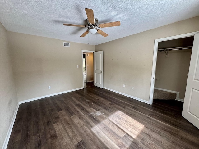 unfurnished bedroom featuring a closet, a textured ceiling, dark hardwood / wood-style floors, and ceiling fan