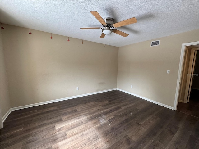 spare room with ceiling fan, a textured ceiling, and dark hardwood / wood-style flooring