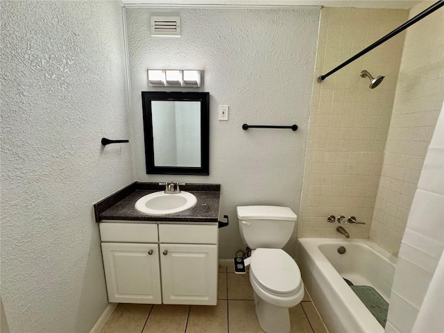 full bathroom featuring vanity, tile patterned floors, toilet, and tiled shower / bath