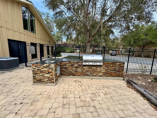 view of patio / terrace with cooling unit, area for grilling, and sink