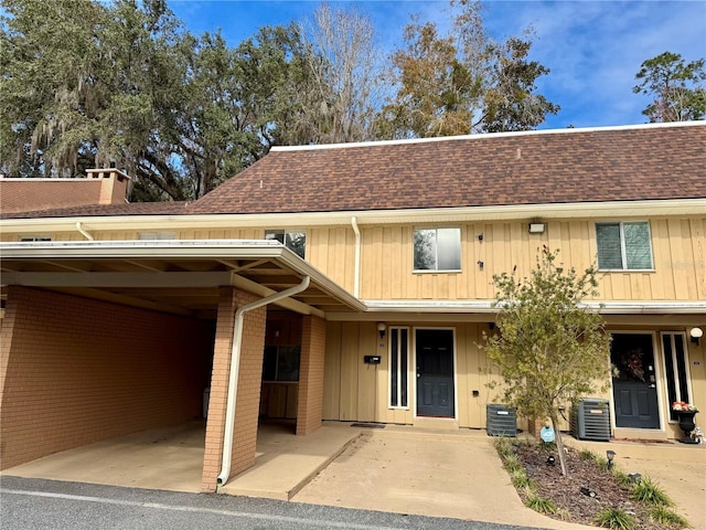 view of front of home with a carport and central AC unit