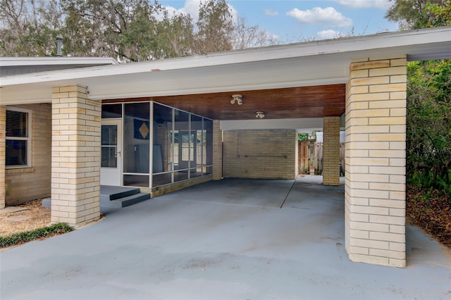 view of patio featuring a carport and a sunroom