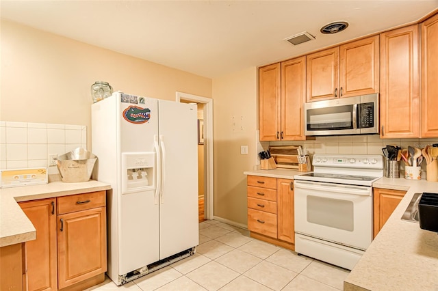 kitchen with sink, light tile patterned floors, white appliances, and decorative backsplash