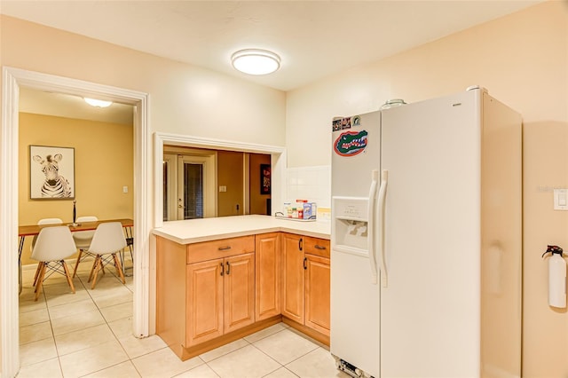 kitchen with white refrigerator with ice dispenser and light tile patterned floors