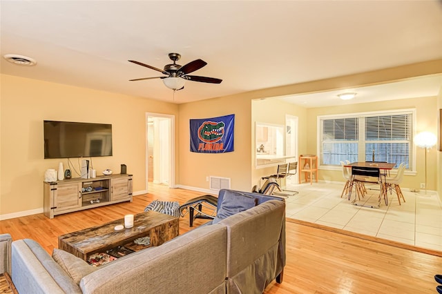 living room with ceiling fan and light wood-type flooring