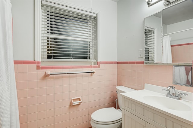 bathroom with vanity, tile walls, and toilet