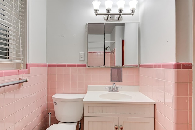 bathroom featuring vanity, toilet, and tile walls