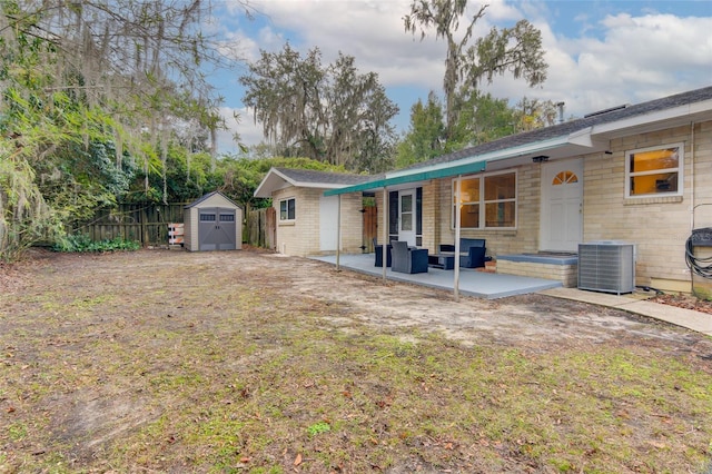 back of property featuring a patio, central AC, and a shed