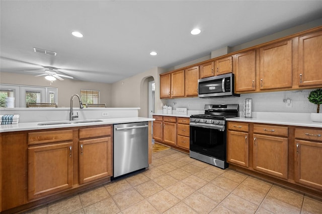 kitchen with tasteful backsplash, ceiling fan, appliances with stainless steel finishes, and sink