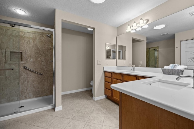 bathroom with vanity, an enclosed shower, toilet, tile patterned floors, and a textured ceiling