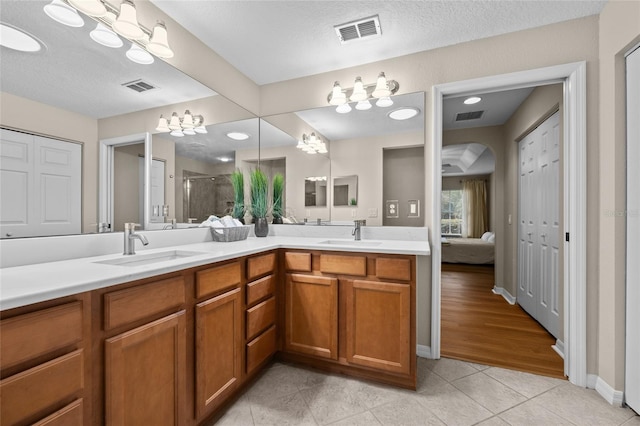 bathroom with vanity, tile patterned floors, a textured ceiling, and walk in shower