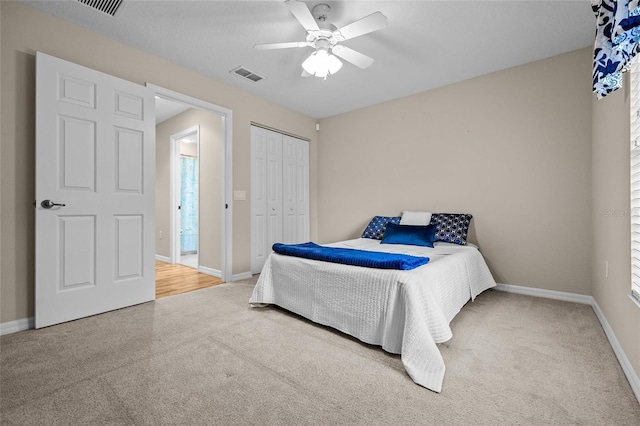 bedroom with ceiling fan, carpet, and a closet