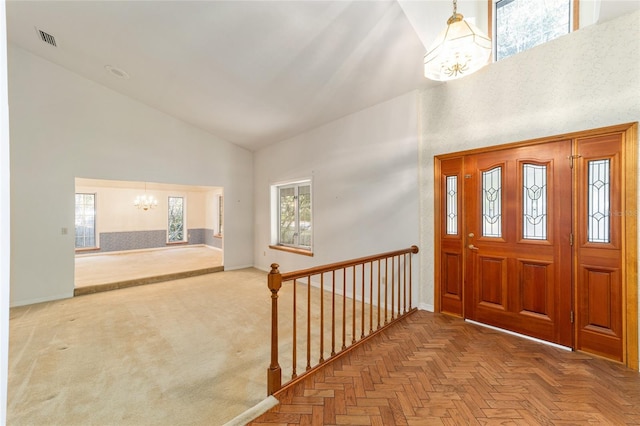 foyer with an inviting chandelier, parquet flooring, and high vaulted ceiling