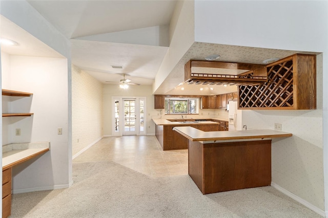 kitchen with french doors, vaulted ceiling, ceiling fan, kitchen peninsula, and light colored carpet