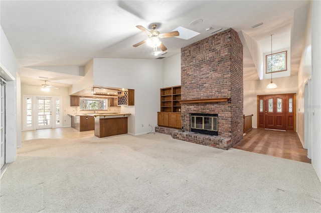 unfurnished living room featuring light colored carpet, a fireplace, and high vaulted ceiling