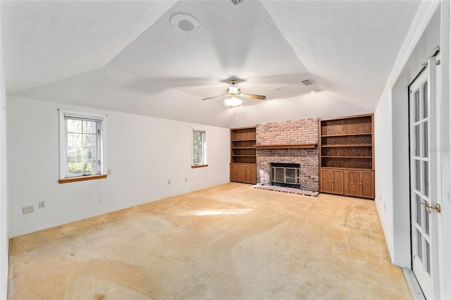 unfurnished living room with light colored carpet, a brick fireplace, vaulted ceiling, and built in features