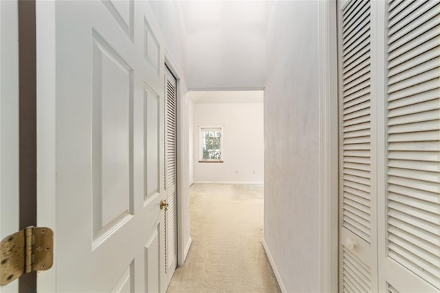 corridor featuring light colored carpet