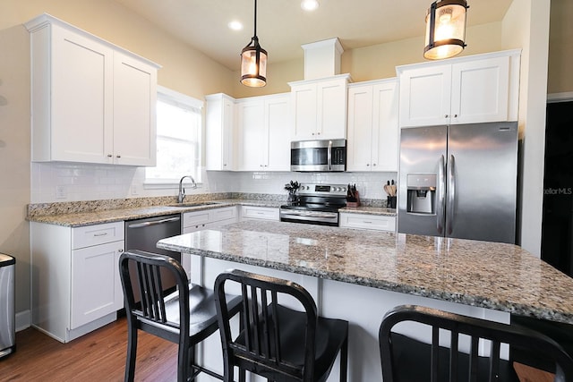 kitchen featuring pendant lighting, sink, white cabinetry, and appliances with stainless steel finishes