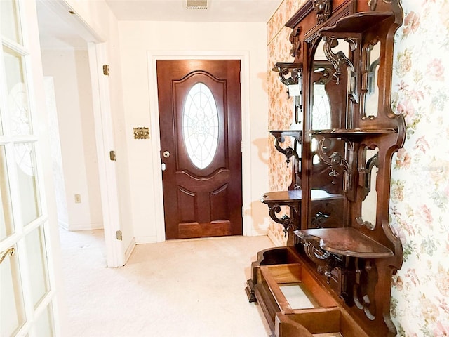 carpeted entryway featuring wallpapered walls, baseboards, and visible vents