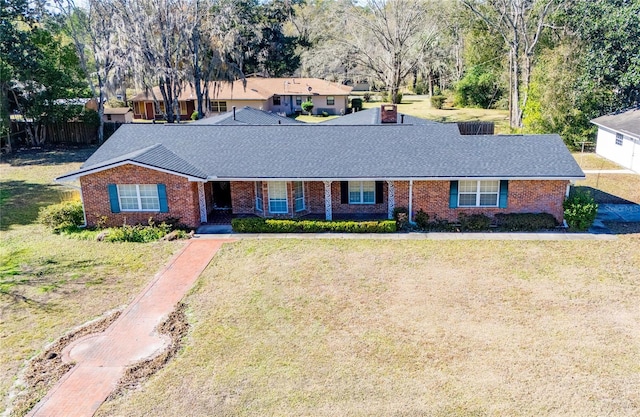 single story home with fence, brick siding, and a front yard
