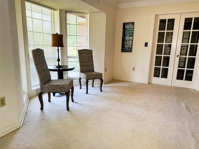 living area featuring french doors, baseboards, carpet, and crown molding