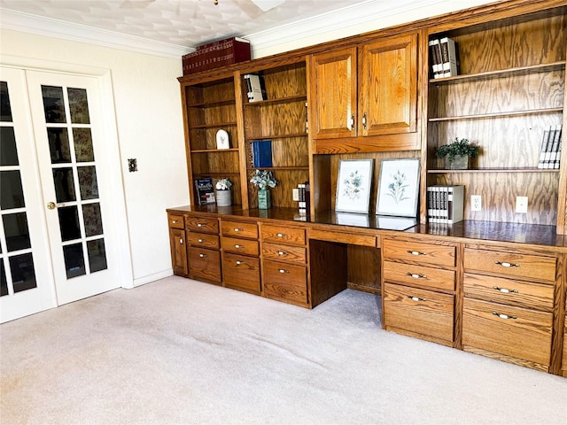 office area featuring built in desk, light colored carpet, and crown molding