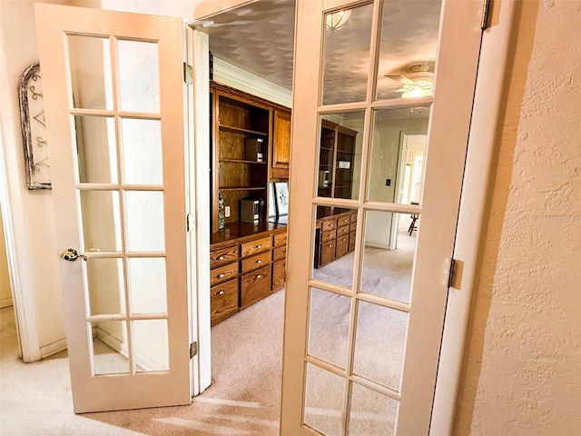 walk in closet featuring light carpet and french doors