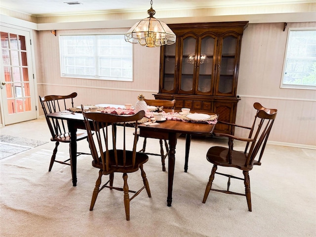 dining area with light carpet, a chandelier, and visible vents