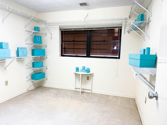 walk in closet featuring visible vents and carpet