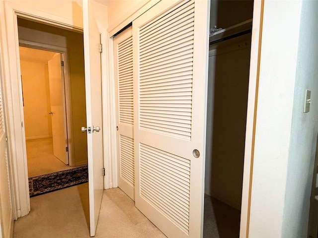 hallway featuring light colored carpet
