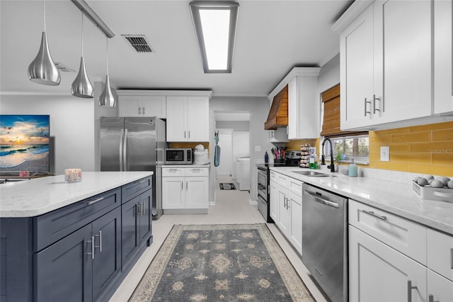 kitchen with white cabinets, stainless steel appliances, pendant lighting, and sink