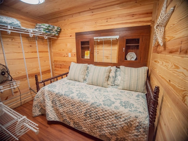 bedroom with wood walls and hardwood / wood-style flooring