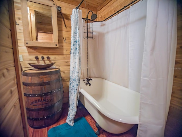 bathroom featuring shower / bathtub combination with curtain, wood walls, and wooden ceiling