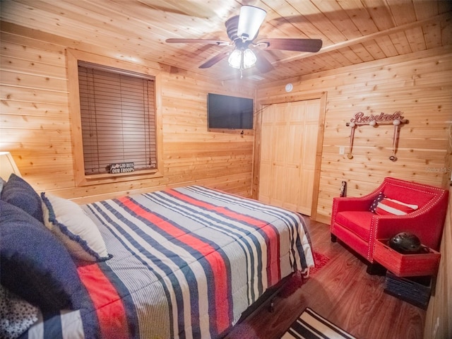 bedroom featuring ceiling fan, wood walls, wooden ceiling, and wood-type flooring