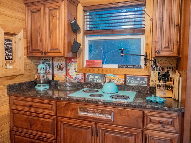 kitchen featuring cooktop and dark stone counters