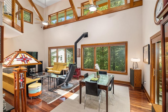 living room featuring ceiling fan, a high ceiling, and light hardwood / wood-style floors