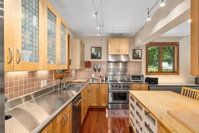 kitchen featuring sink, stainless steel appliances, stainless steel counters, and backsplash