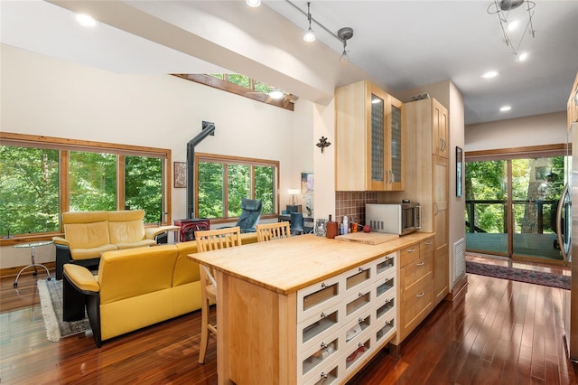 kitchen featuring wooden counters, a breakfast bar area, and light brown cabinets