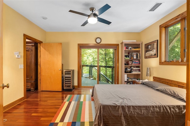 unfurnished bedroom featuring ceiling fan, access to exterior, and dark hardwood / wood-style floors